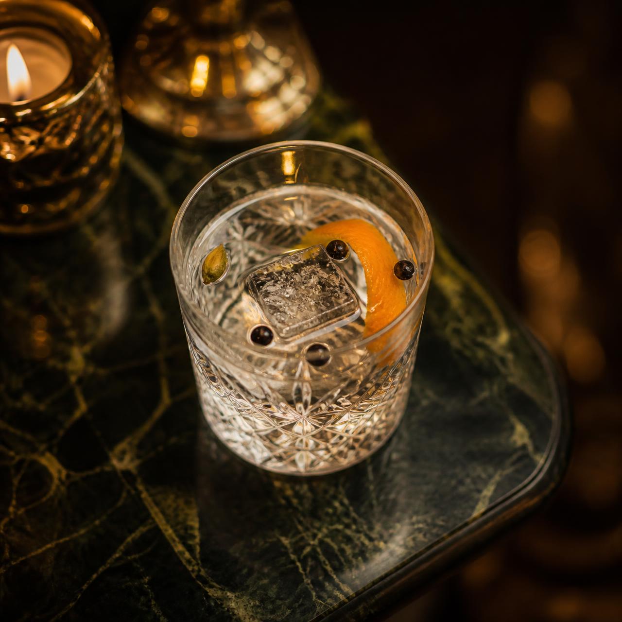 A crystal glass gin serve with orange peel